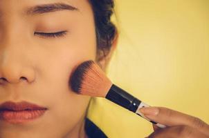 Beauty face of Asian woman by applying brushes on skin by cosmetics. photo