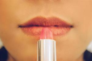 rostro de belleza de mujer mediante la aplicación de lápiz labial en la boca por cosméticos. foto