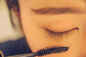 rostro de belleza de mujer mediante la aplicación de rímel en el ojo por cosméticos. foto