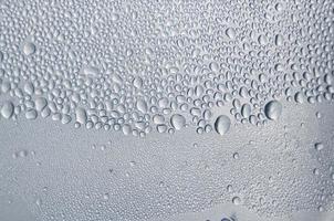 Fondo y papel tapiz por gota de lluvia y gotas de agua en la ventana. foto