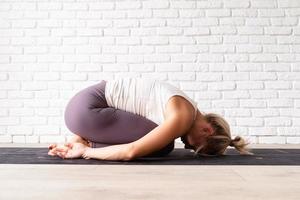 Atractiva mujer joven practicando yoga, vistiendo ropa deportiva foto