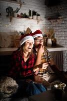 Couple watching movies at home at Christmas pointing to the screen photo