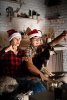 pareja viendo películas en casa en navidad apuntando a la pantalla foto