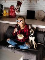 Mujer con gafas 3D viendo películas en casa por la noche en Navidad foto