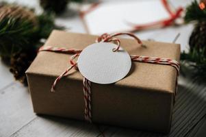 Caja de regalo con un pequeño regalo sobre un fondo de madera blanca