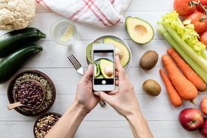 Female hands taking a picture of healthy food top view flat lay