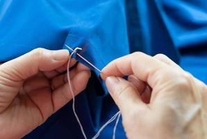 Woman using needle to sew photo