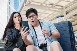 Couple love traveller looking smartphone and feel shocked.