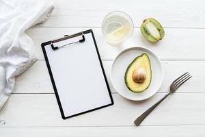 Detox plan of avocado and kiwi and blank notepad, top view flat lay
