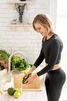 Woman washing celery in the kitchen sink photo