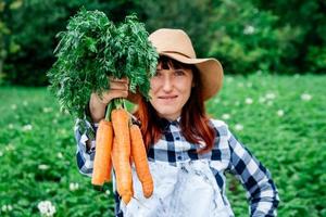 mujer sosteniendo zanahorias foto