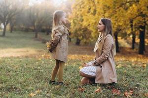 Mother and her daughter have fun and walk in the autumn park. photo