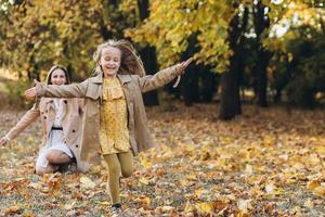 madre y su hija se divierten y caminan en el parque de otoño. foto