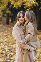 Mother and her daughter have fun and walk in the autumn park. photo