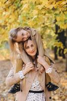 Mother and her daughter have fun and walk in the autumn park. photo