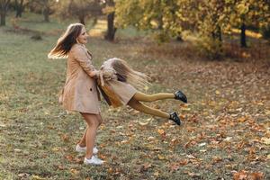 Mother and her daughter have fun and walk in the autumn park. photo