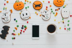 Cup of coffee and smartphone with candy and gingerbread photo
