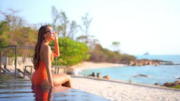 Young asian woman enjoys outdoor swimming pool video