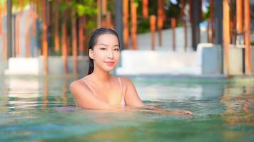 Young asian woman enjoys outdoor swimming pool video