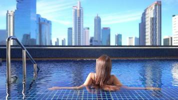 joven asiática disfruta de la piscina al aire libre video