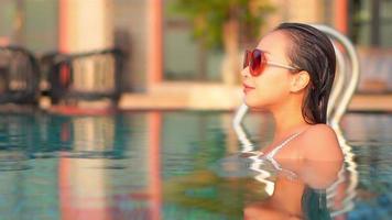 une jeune femme asiatique profite d'une piscine extérieure video