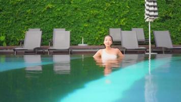 Young woman enjoys around outdoor swimming pool video