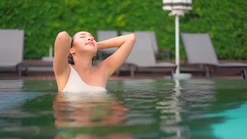 mujer joven disfruta alrededor de la piscina al aire libre