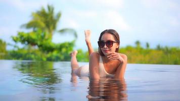 mujer joven disfruta alrededor de la piscina al aire libre