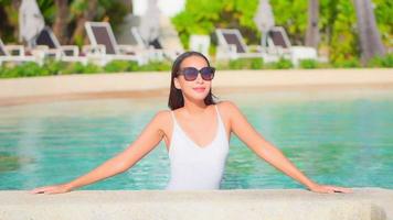 Young woman enjoys around outdoor swimming pool
