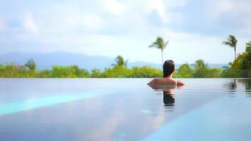 Young woman enjoys around outdoor swimming pool video