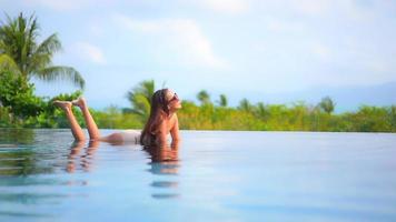 Young woman enjoys around outdoor swimming pool video