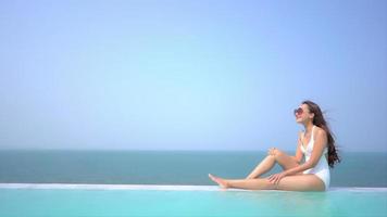 Young woman enjoys around outdoor swimming pool video