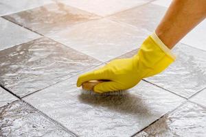 Using a wooden floor scrubber to scrub the tile floor. photo