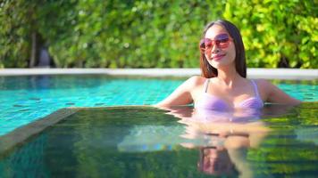 mujer joven disfruta alrededor de la piscina al aire libre video