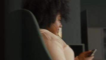 mulher com fones de ouvido e smartphone sentada e tocando música video