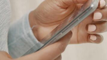 Close up of fingers of woman touching smartphone and woman smiles video