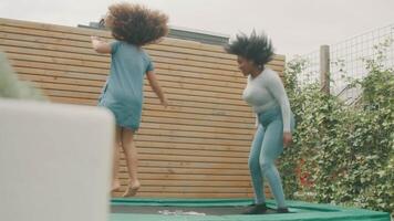 niña y mujer saltando en trampolín video