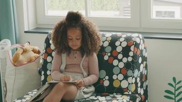 niña sentada leyendo en voz alta video