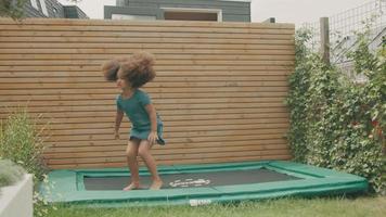 Girl jumping on trampoline smiling video
