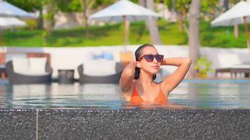 Young woman enjoys around outdoor swimming pool video