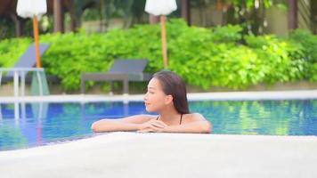 mujer joven disfruta alrededor de la piscina al aire libre video