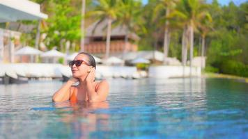 Young woman enjoys around outdoor swimming pool video