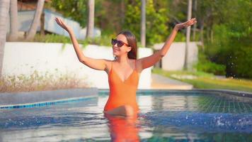 mujer joven disfruta alrededor de la piscina al aire libre video