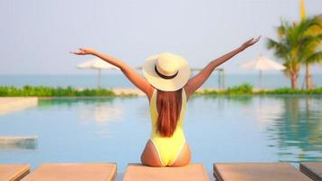 Young woman enjoys around outdoor swimming pool video