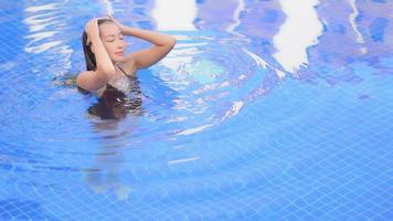 Young woman enjoys around outdoor swimming pool video