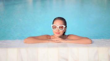 mujer joven disfruta alrededor de la piscina al aire libre video