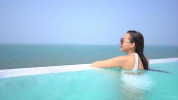 mujer joven disfruta alrededor de la piscina al aire libre video