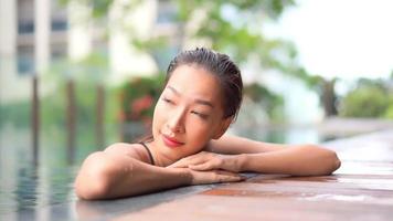 Young woman enjoys around outdoor swimming pool video