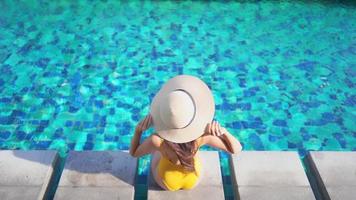 mujer joven disfruta alrededor de la piscina al aire libre video