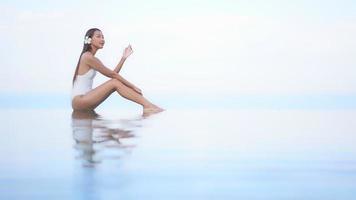 la giovane donna si diverte intorno alla piscina all'aperto video